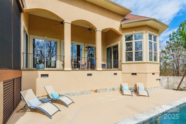 back of house with ceiling fan, a patio, a shingled roof, and stucco siding