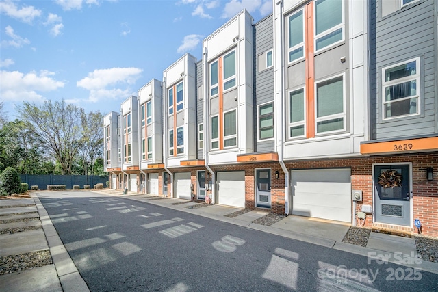 view of building exterior with an attached garage and a residential view