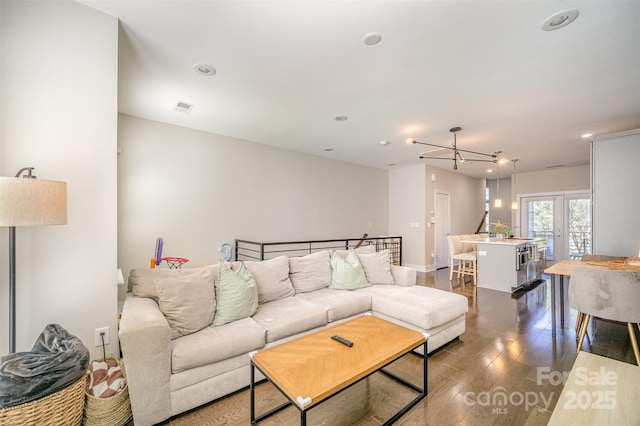 living room featuring visible vents, recessed lighting, an inviting chandelier, and dark wood-style flooring