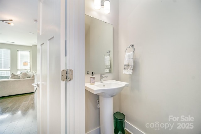 bathroom featuring connected bathroom, wood finished floors, and a sink