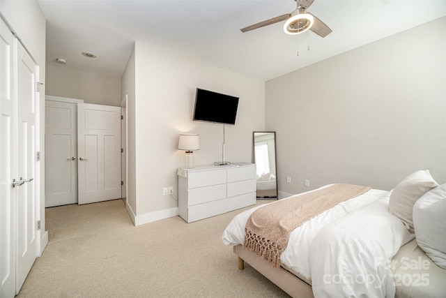 bedroom featuring baseboards, light colored carpet, and a ceiling fan