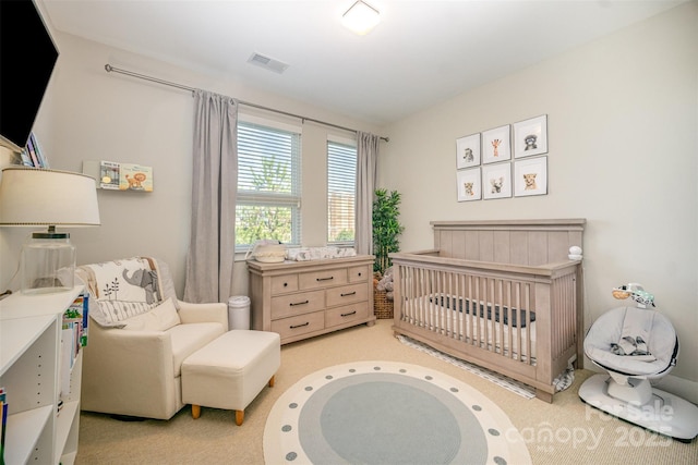 carpeted bedroom with a crib and visible vents