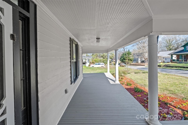 wooden deck featuring covered porch and a residential view