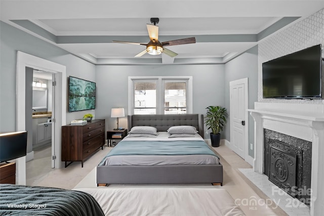 bedroom featuring ceiling fan, ornamental molding, ensuite bathroom, and a high end fireplace