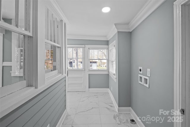 interior space with baseboards, marble finish floor, and crown molding