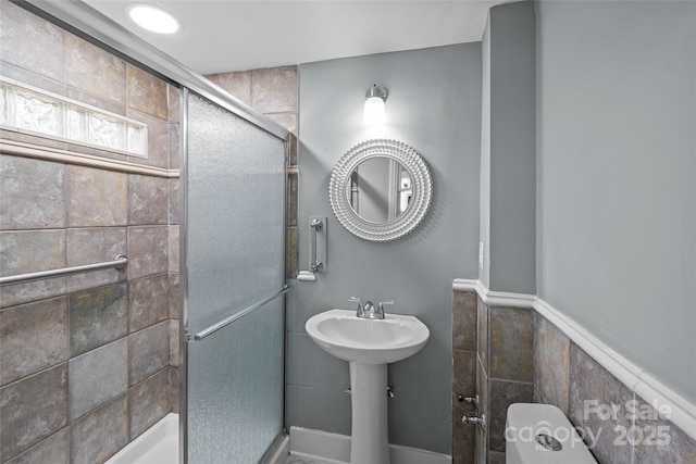 bathroom featuring a stall shower and toilet