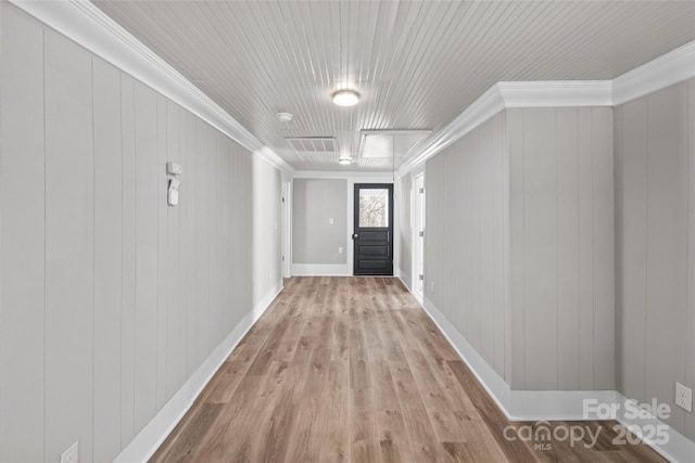 corridor featuring ornamental molding, baseboards, and wood finished floors