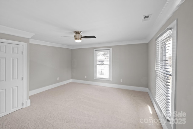 unfurnished room with light carpet, baseboards, visible vents, and crown molding