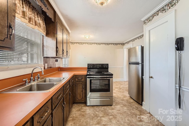 kitchen featuring stainless steel appliances, dark brown cabinets, a sink, and light countertops