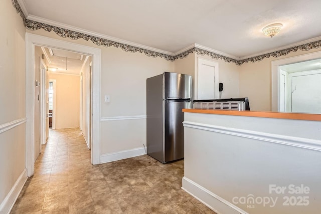 kitchen with baseboards, ornamental molding, and freestanding refrigerator