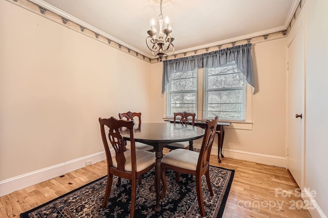 dining area with crown molding, light wood-style floors, baseboards, and an inviting chandelier