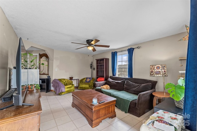 living room featuring arched walkways, light tile patterned floors, and ceiling fan