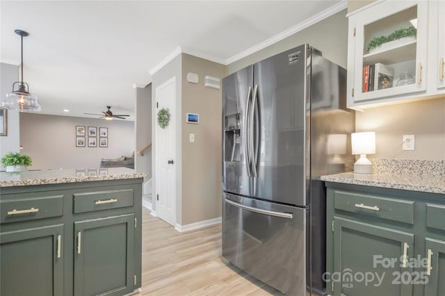 kitchen featuring hanging light fixtures, crown molding, stainless steel refrigerator with ice dispenser, and green cabinets