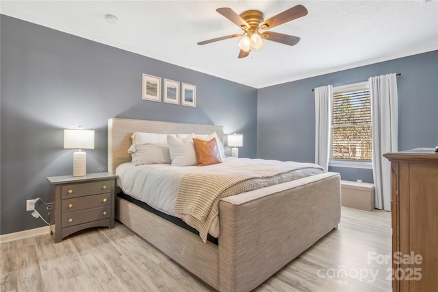 bedroom featuring light wood-style floors, ornamental molding, baseboards, and ceiling fan