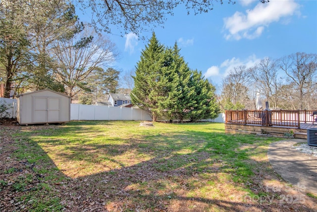 view of yard featuring an outdoor structure, a deck, a storage shed, and fence