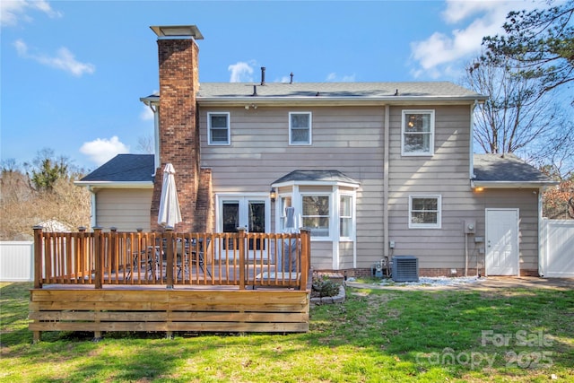 back of house with a chimney, a lawn, central AC, fence, and a wooden deck