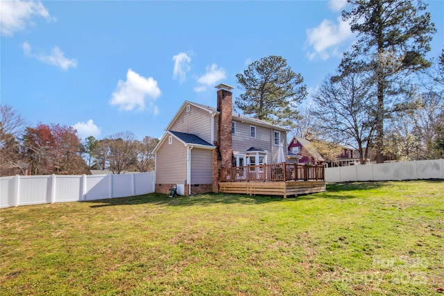 rear view of house with crawl space, a fenced backyard, a lawn, and a deck