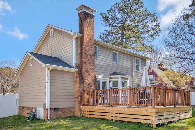 rear view of property featuring a deck, crawl space, a chimney, and fence