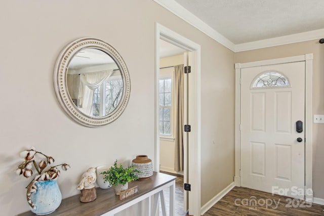 foyer with ornamental molding, wood finished floors, and baseboards