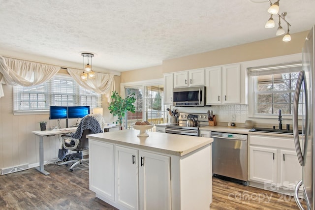 kitchen with dark wood finished floors, stainless steel appliances, light countertops, visible vents, and white cabinets