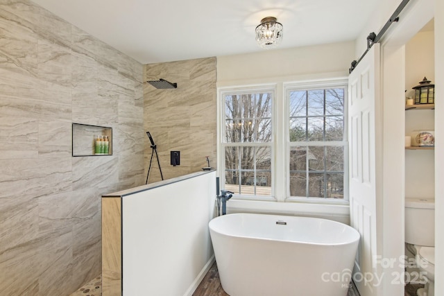 bathroom featuring a walk in shower, a freestanding tub, and toilet