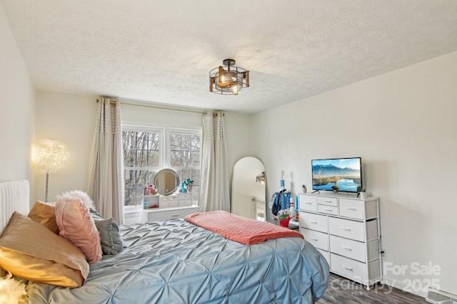 bedroom with visible vents, dark wood-type flooring, and a textured ceiling