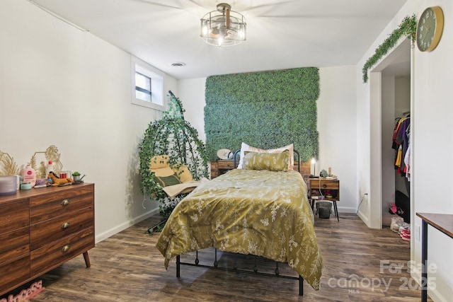 bedroom featuring visible vents, baseboards, and wood finished floors