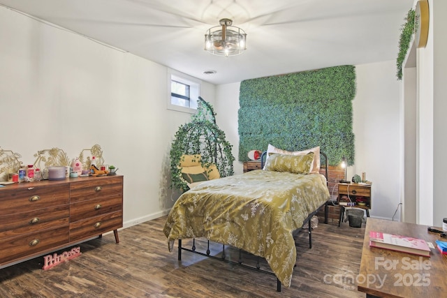 bedroom with wood finished floors and baseboards