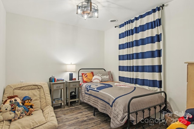 bedroom featuring visible vents and wood finished floors