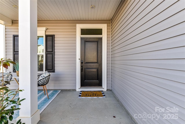 view of exterior entry featuring covered porch