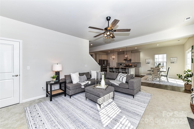 living room featuring visible vents, baseboards, ceiling fan, light colored carpet, and recessed lighting