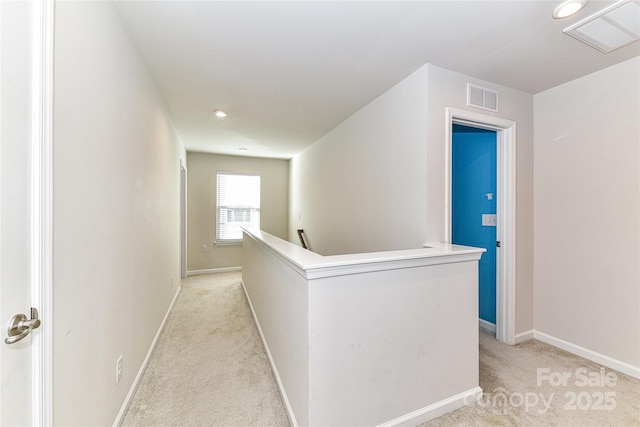 corridor featuring light carpet, visible vents, an upstairs landing, and baseboards