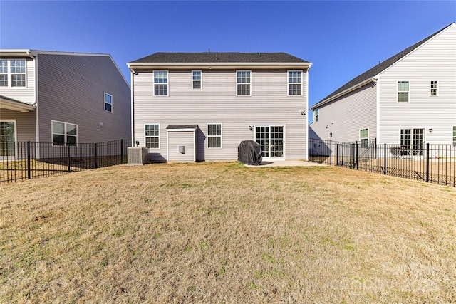 back of property with a fenced backyard, a patio area, central AC, and a yard