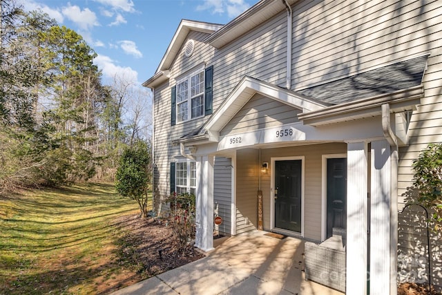 doorway to property with a shingled roof