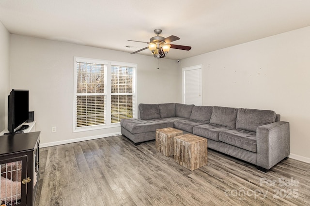 living room featuring ceiling fan, wood finished floors, and baseboards