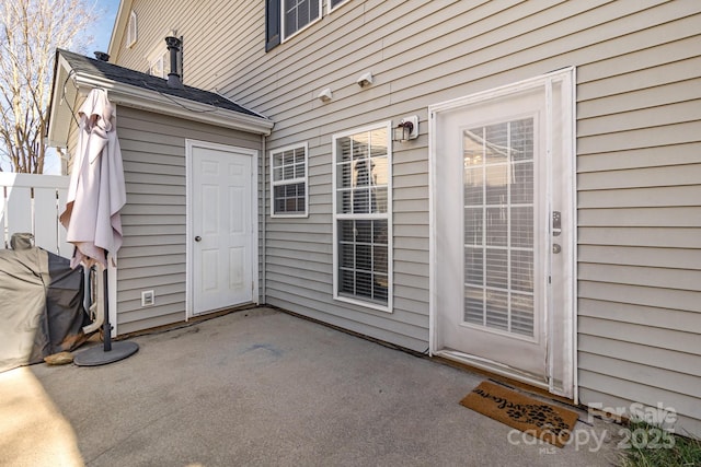 view of exterior entry with a patio