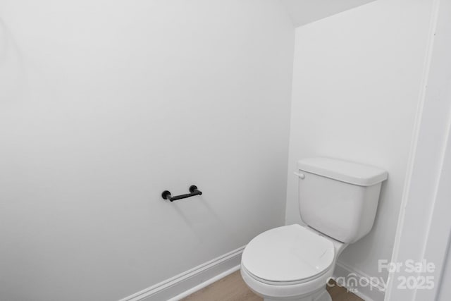 bathroom with baseboards and toilet