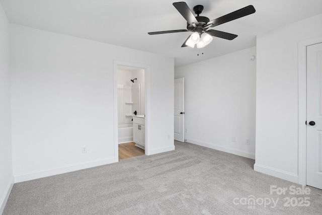 unfurnished bedroom with ceiling fan, baseboards, light carpet, and connected bathroom