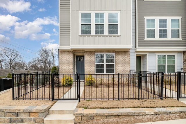 view of front facade featuring a fenced front yard and brick siding