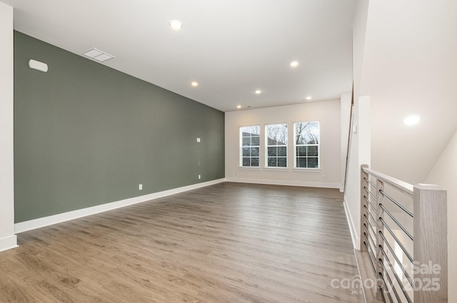 spare room featuring visible vents, baseboards, wood finished floors, and recessed lighting