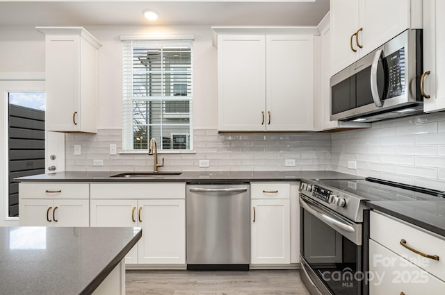 kitchen with a healthy amount of sunlight, tasteful backsplash, appliances with stainless steel finishes, and a sink