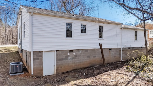 view of property exterior with a shingled roof, crawl space, and central AC