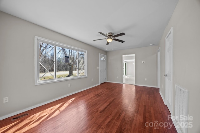 interior space featuring hardwood / wood-style flooring, baseboards, visible vents, and ceiling fan