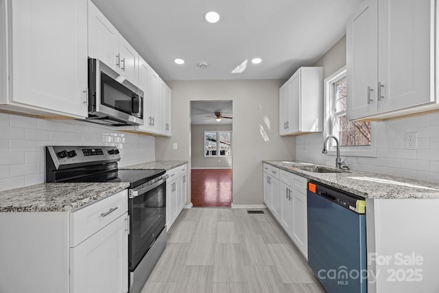 kitchen with a healthy amount of sunlight, a ceiling fan, appliances with stainless steel finishes, and a sink