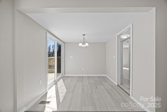 interior space with baseboards, visible vents, and a chandelier