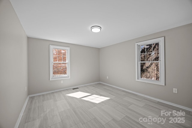 unfurnished room with baseboards