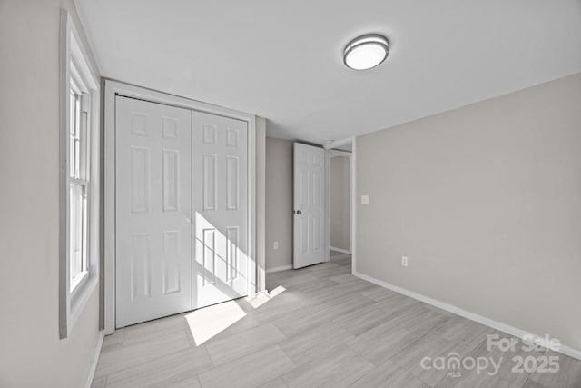 unfurnished bedroom with a closet and baseboards