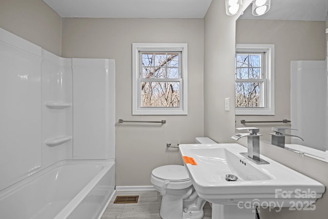 bathroom featuring baseboards, visible vents, toilet, wood finished floors, and a sink