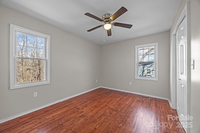 unfurnished bedroom with visible vents, ceiling fan, baseboards, and hardwood / wood-style flooring