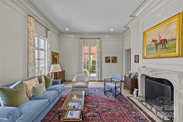 living room with a decorative wall, a fireplace, and crown molding